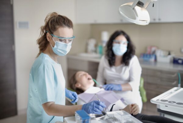 Prothésiste tenant une couronne en zircone monolithique sur un plan de travail de laboratoire dentaire